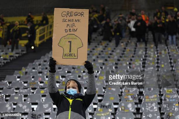 Fan of Borussia Dortmund holds up a placard asking for the jersey of Dortmund gopalkeeper Gregor Kobel prior to the Bundesliga match between Borussia...