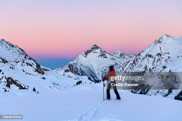 skier in ski-resort lech after sunset - lech stock pictures, royalty-free photos & images