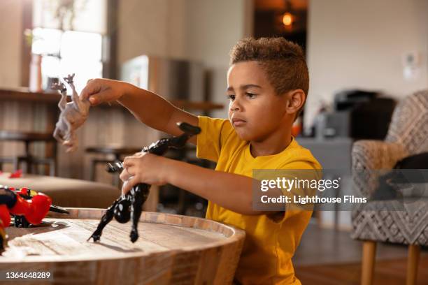 boy plays with toy dinosaur and toys - dinosaur toy i stock pictures, royalty-free photos & images