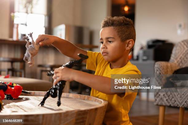 boy plays with toy dinosaur and toys - dinosaur toy i - fotografias e filmes do acervo