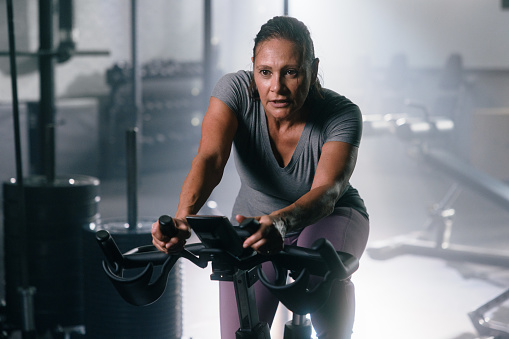 Woman works out on exercise bike in gym