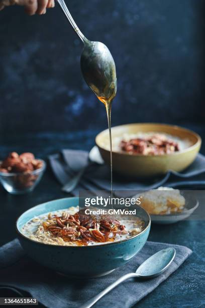 porridge con noci pecan e miele - fiocchi di avena foto e immagini stock