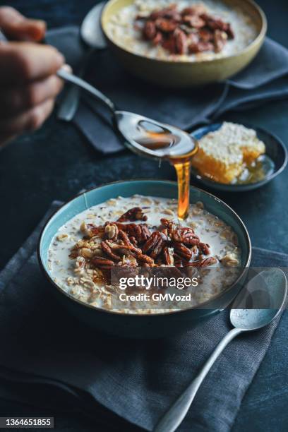gachas con nueces pecán y miel - gachas de avena fotografías e imágenes de stock
