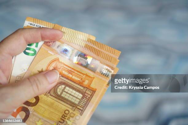 hand holding out money, euro paper currency - eu valuta foto e immagini stock