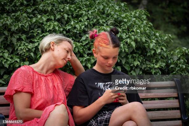 teen girl holding mobile phone and looking at the screen. problems of diverse generations. youth culture - relationship difficulties photos stock pictures, royalty-free photos & images
