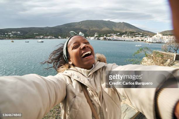 selfie of a happy black woman on holidays - black influencer stock pictures, royalty-free photos & images