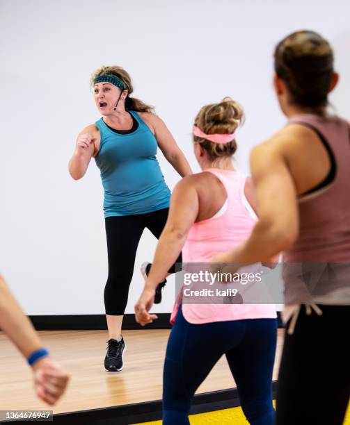 hispanic instructor leading dance exercise class - aerobic stockfoto's en -beelden