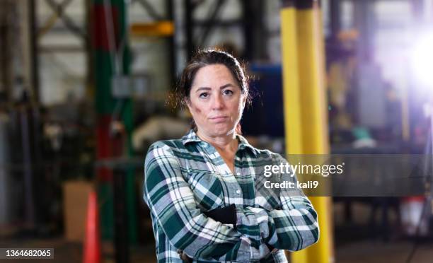 mature woman standing in warehouse - toughness 個照片及圖片檔