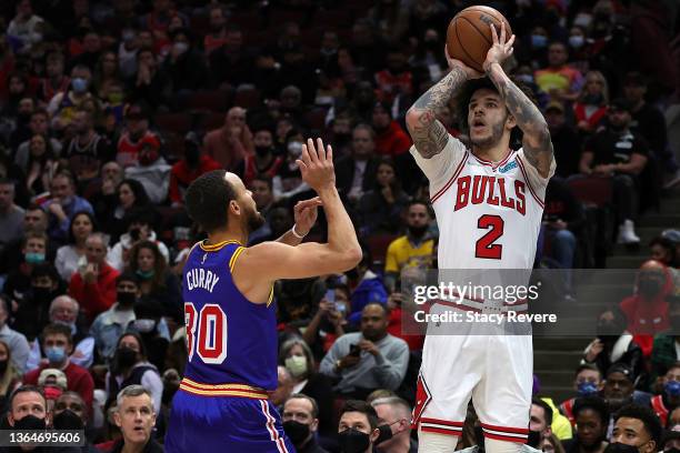 Lonzo Ball of the Chicago Bulls shoots over Stephen Curry of the Golden State Warriors during a game at United Center on January 14, 2022 in Chicago,...