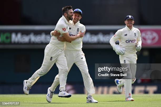 Mark Wood of England celebrates his wicket of Pat Cummins of Australia with Joe Root during day two of the Fifth Test in the Ashes series between...