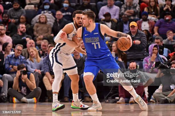 Tyus Jones of the Memphis Grizzlies guards Luka Doncic of the Dallas Mavericks during the second half at FedExForum on January 14, 2022 in Memphis,...