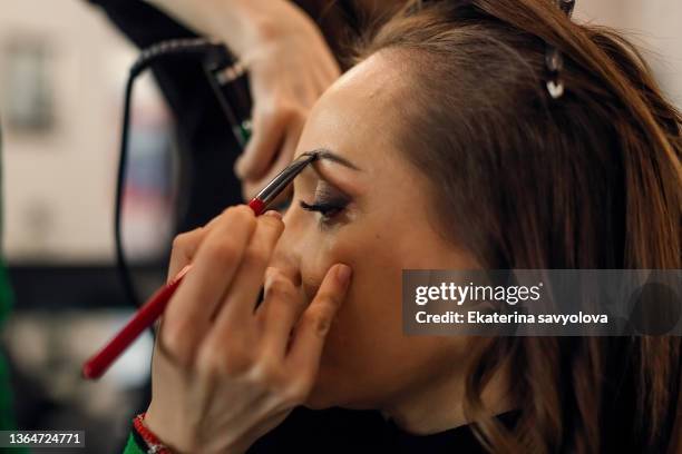 applying makeup. close-up. - maquillador fotografías e imágenes de stock
