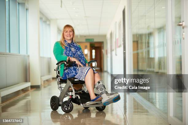 portrait smiling woman wearing medical boot in wheelchair - woman in broken shoe heel stockfoto's en -beelden