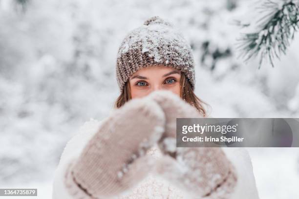 attractive cheerful young female having fun in snowy pine tree forest. - orange glove stock pictures, royalty-free photos & images