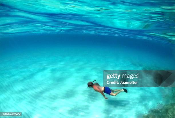 young man snorkeling in ses illetes, formentera - formentera fotografías e imágenes de stock