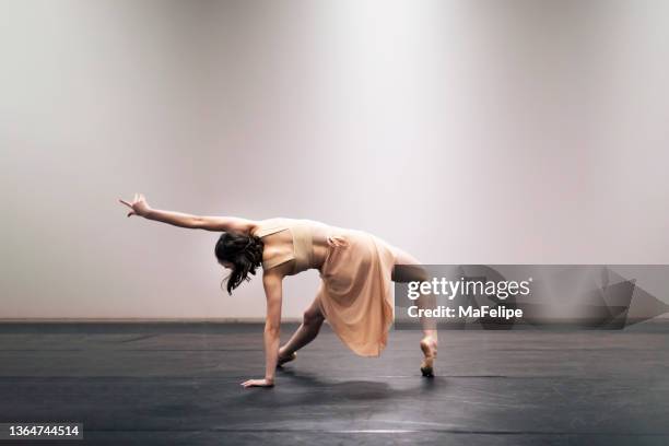 young girl performing contemporary dance on stage - hedendaagse dans stockfoto's en -beelden