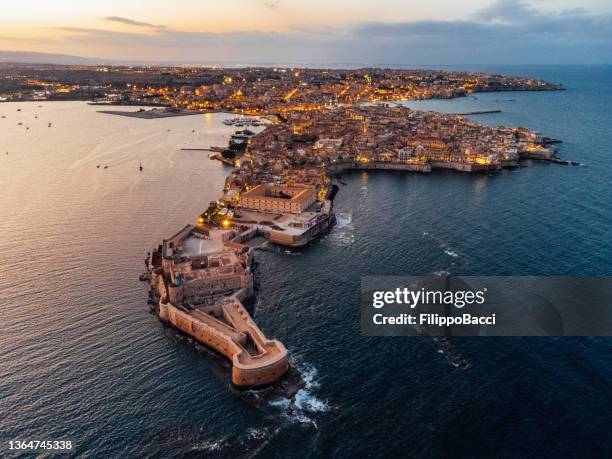 luftaufnahme der insel ortigia und der stadt syrakus bei sonnenuntergang - ortygia stock-fotos und bilder