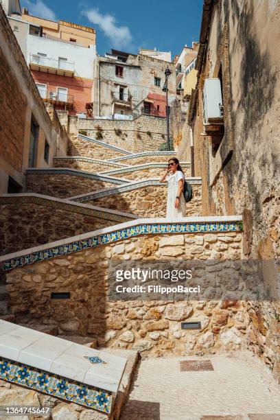 eine frau steht auf einer zick-zack-treppe in sciacca, sizilien, italien - mezzogiorno stock-fotos und bilder