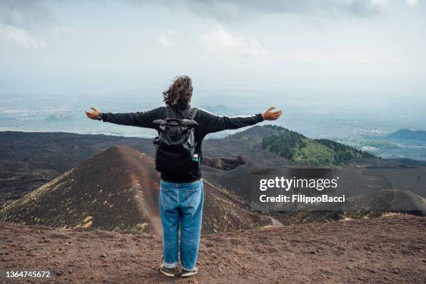 a man is admiring a panoramic view of mount etna, an active volcano in sicily, italy - cool nature stock pictures, royalty-free photos & images