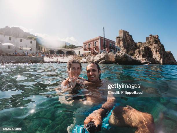 pov view of a couple taking a selfie in scopello beach, sicily, italy - sicily stock pictures, royalty-free photos & images