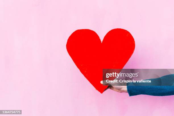 hand holding a big red heart - things that go together imagens e fotografias de stock