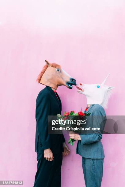 couple kissing with horse masks on pink background - funny horses 個照片及圖片檔