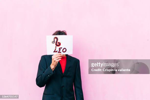 young man holding a leo zodiac sign poster - brand name stockfoto's en -beelden