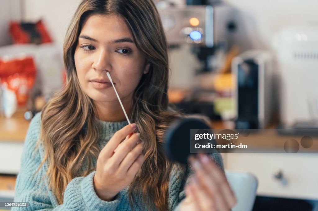 Junge Frau testet sich zu Hause selbst auf COVID-19