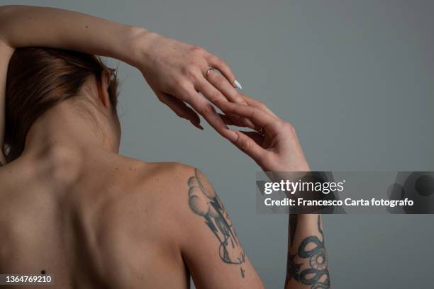 rear view of topless young woman with tattoo - tattoo closeup stock pictures, royalty-free photos & images