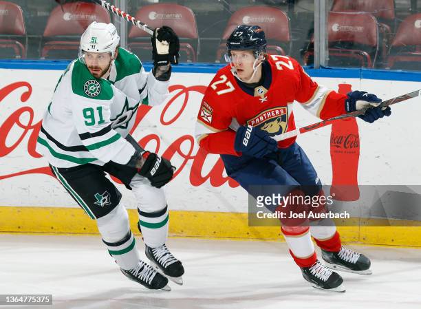 Tyler Seguin of the Dallas Stars and Eetu Luostarinen of the Florida Panthers skate after a loose puck at the FLA Live Arena on January 14, 2022 in...