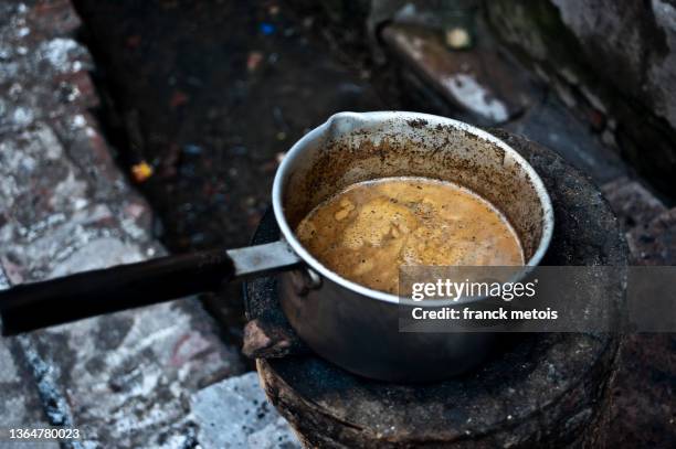 heating the tea above the sewer ( india) - dirty pan stock pictures, royalty-free photos & images