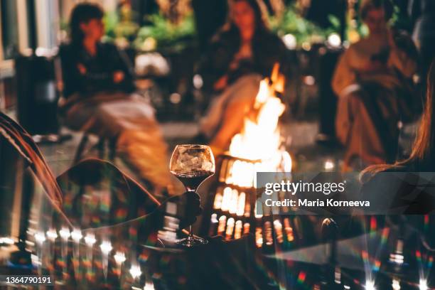 black firewood burns in bright flame in old metal brazier with grid against blurred background with bokeh effect in summer evening extreme closeup - brasero photos et images de collection