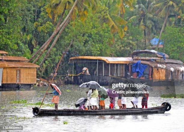 männer mit regenschirmen stehen auf einem überfüllten punt im regen, cochin, kerala wasserstraßen, indien - kerala rain stock-fotos und bilder