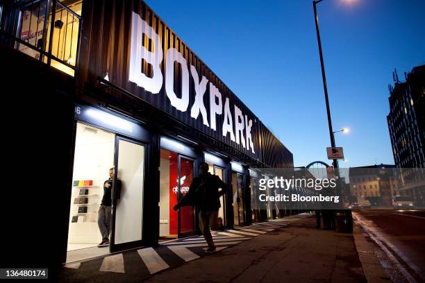 Pedestrians pass the Boxpark pop-up retail mall in London, U.K., on Thursday, Jan. 5, 2012. Sixty shipping containers form a temporary retail mall...