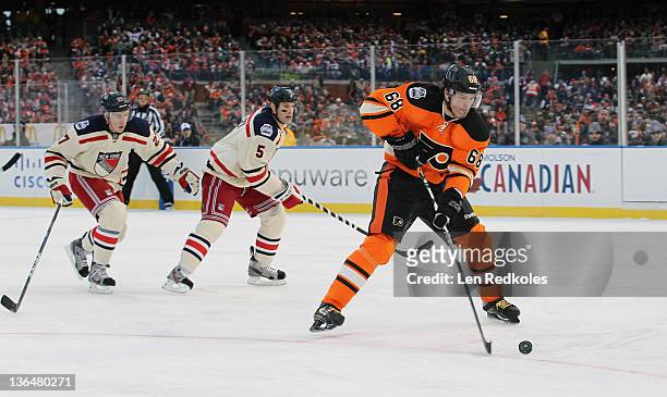 Jaromir Jagr of the Philadelphia Flyers skates the puck through the defense of Ryan McDonagh and Dan Girardi of the New York Rangers during the 2012...