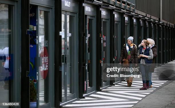 Pedestrians browse window displays at the Boxpark pop-up retail mall in London, U.K., on Wednesday, Jan. 4, 2012. Sixty shipping containers form a...