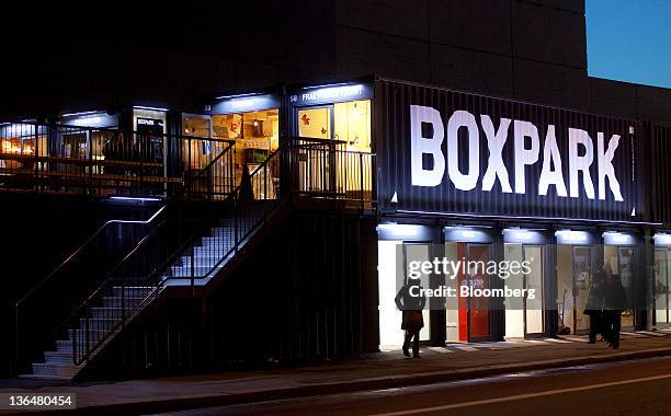 Pedestrians pass the Boxpark pop-up retail mall in London, U.K., on Thursday, Jan. 5, 2012. Sixty shipping containers form a temporary retail mall...