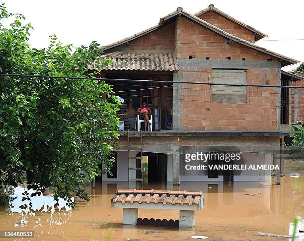 Local resident remains on the upper floor of her home in a flooded area of the Tres Vendas neighborhood in Campos, 300 km north of Rio de Janeiro,...