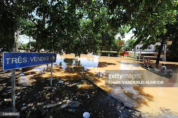 Local residents navigate on a boat along a flooded street at the Tres Vendas neighborhood in Campos, 300 km north of Rio de Janeiro, Brazil, on...