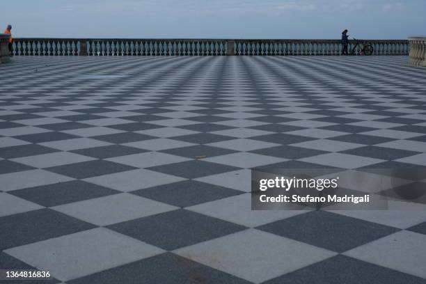 paved checkerboard square with balcony overlooking the sea - balustrade foto e immagini stock