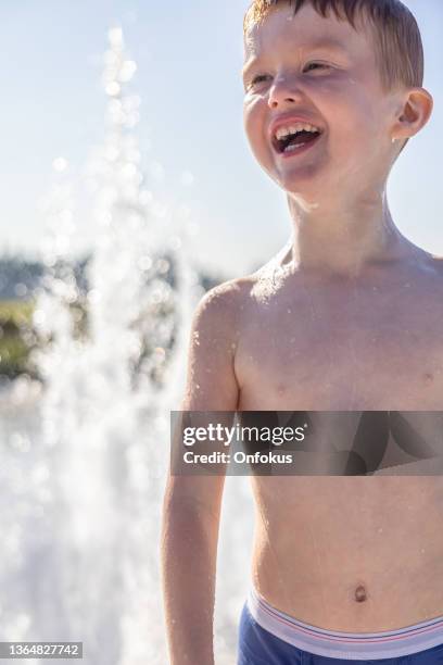 cute redhead boy playing in the water fountain, fontaine du quai paquet, lévis, quebec, canada - kids in undies stock pictures, royalty-free photos & images
