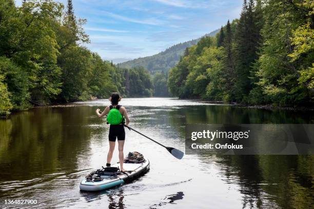 mujer paddleboarding en el río en verano - sunday in the valley fotografías e imágenes de stock