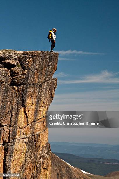 woman hiker standing on cliff edge - strapiombo foto e immagini stock