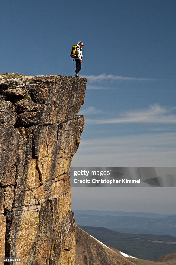 Woman hiker standing on cliff edge