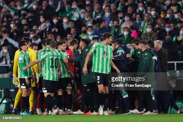 Players gather around Joan Jordan of Sevilla FC after being hit by a stick thrown from the stand during the Real Betis Balompie and Sevilla Copa del...