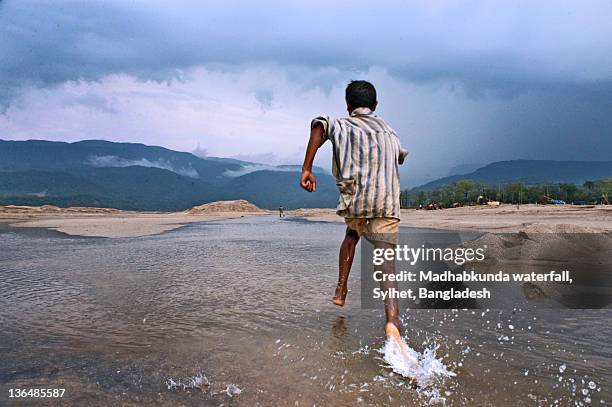 boy running on beach - madhabkunda stock pictures, royalty-free photos & images