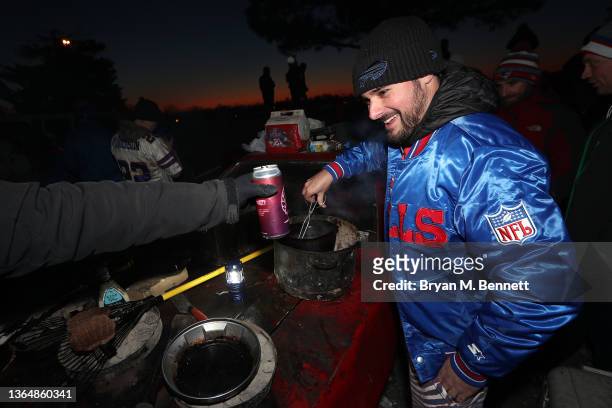 Fan smiles as he cooks food at a pregame tailgate festivities prior to the AFC Wild Card playoff game between the New England Patriots and the...