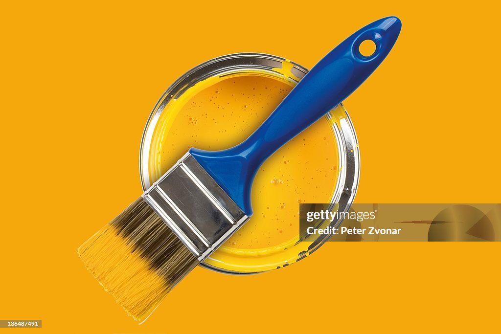 Yellow paint can with brush