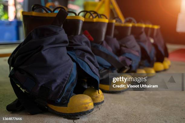 boots on floor and equipment ready for operation inside fire station. - firefighter boot stock pictures, royalty-free photos & images