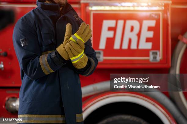 fireman in protective suit standing near fire truck with equipment. - bayonne new jersey stock pictures, royalty-free photos & images